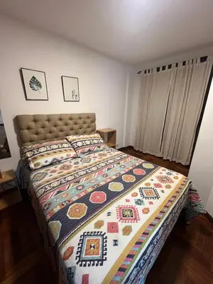 a bedroom with a bed with a colorful quilt at Palacio 210 - Plaza España - Nueva Córdoba - 2 dormitorios in Cordoba