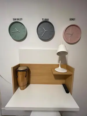 three clocks on a wall with a bench and a lamp at Palacio 210 - Plaza España - Nueva Córdoba - 2 dormitorios in Cordoba