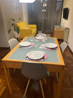 a wooden table with plates and wine glasses on it at Palacio 210 - Plaza España - Nueva Córdoba - 2 dormitorios in Cordoba