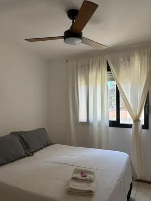 a bedroom with a bed with a ceiling fan and a window at Departamento Centrico Nueva Cordoba in Cordoba
