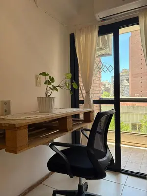 a desk and a chair in a room with a window at Departamento Centrico Nueva Cordoba in Cordoba