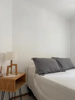 a bedroom with a bed and a nightstand with a lamp at Departamento Centrico Nueva Cordoba in Cordoba