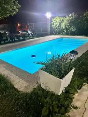 a swimming pool at night with a blue pool at Departamento LAS ARAUCARIAS in Arroyo de Los Patos