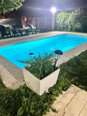 a pool at night with a plant in a planter at Departamento LAS ARAUCARIAS in Arroyo de Los Patos