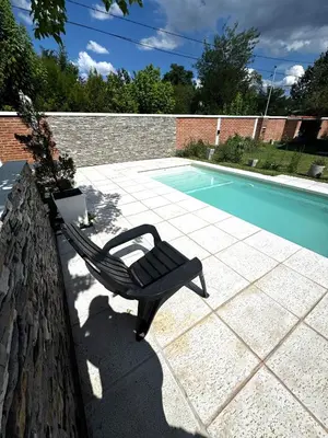 a chair sitting on a wall next to a swimming pool at Departamento LAS ARAUCARIAS in Arroyo de Los Patos