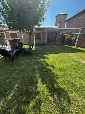 a yard with two chairs and a table and a tree at Departamento LAS ARAUCARIAS in Arroyo de Los Patos
