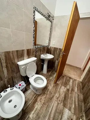 a bathroom with a toilet and a sink at Departamento LAS ARAUCARIAS in Arroyo de Los Patos
