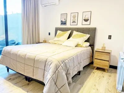 a bedroom with a large bed with yellow pillows at Constantino 6 Apartments in Villa Carlos Paz