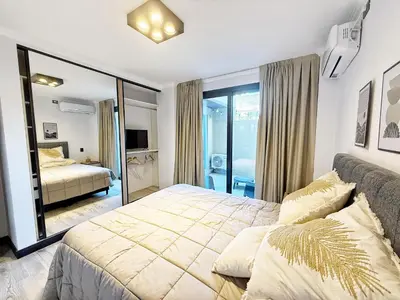 a bedroom with a large bed and a mirror at Constantino 6 Apartments in Villa Carlos Paz