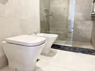 a white bathroom with a toilet and a shower at Constantino 6 Apartments in Villa Carlos Paz