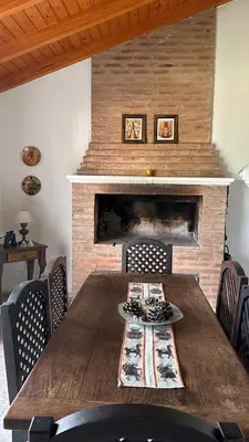 a wooden table in a room with a fireplace at Casa vista panorámica al lago in Cordoba