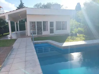 a house with a swimming pool in front of a house at Casa vista panorámica al lago in Cordoba