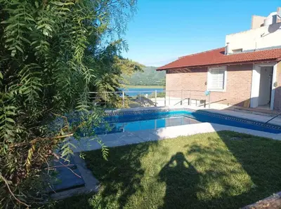 a shadow of a person standing in the grass near a pool at Casa vista panorámica al lago in Cordoba