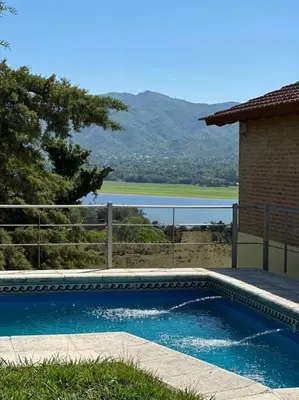 a swimming pool in front of a house with a view at Casa vista panorámica al lago in Cordoba