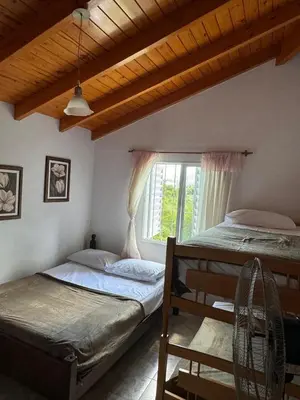 two beds in a room with a window at Casa vista panorámica al lago in Cordoba