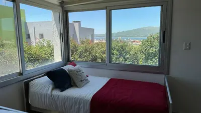a bed in a room with two large windows at Casa Paris Puerto del Aguila in Potrero de Garay