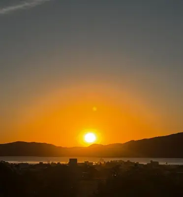 a sunset over the water with the sun in the sky at Casa Paris Puerto del Aguila in Potrero de Garay
