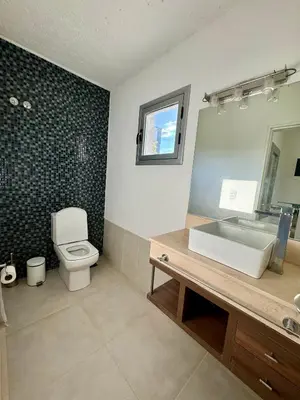 a bathroom with a toilet and a sink and a mirror at Casa Paris Puerto del Aguila in Potrero de Garay
