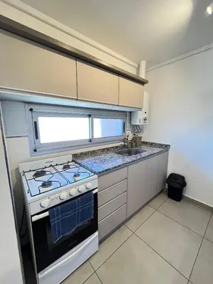 a kitchen with a stove and a sink at Departamento cómodo y confortable en Córdoba Capital in Cordoba