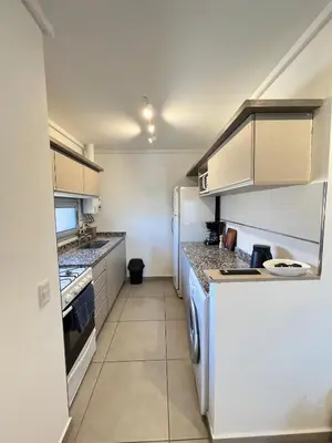 a kitchen with a refrigerator and a dishwasher at Departamento cómodo y confortable en Córdoba Capital in Cordoba