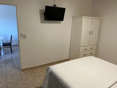 a bedroom with a bed and a cabinet with a television at Bella Luna apart in Mina Clavero