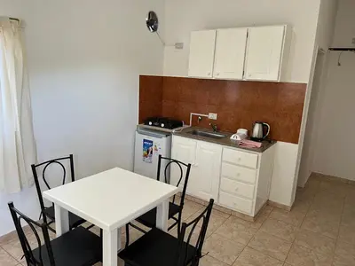 a kitchen with a table and a white table and chairs at Bella Luna apart in Mina Clavero