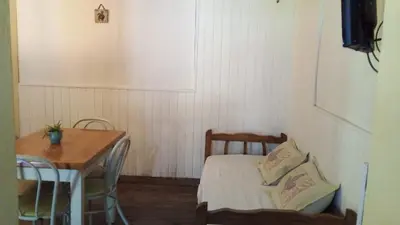 a small room with a table and a bed and a table and chair at Alojamiento frente al Arroyo Cristal in Tanti