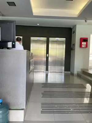 a lobby with three elevators and a man in a building at CR Apartment in Cordoba