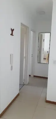 a hallway with white walls and a mirror at CR Apartment in Cordoba