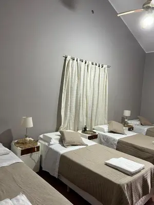 a room with three beds and a window at La Posta del Jesuita in Villa Los Aromos