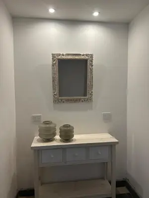 a table with a mirror on a white wall at La Posta del Jesuita in Villa Los Aromos