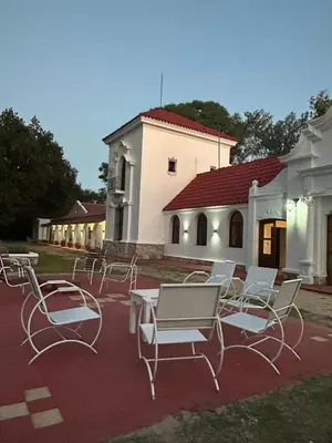 a group of chairs and tables in front of a building at La Posta del Jesuita in Villa Los Aromos