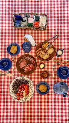 a table with plates of food on a red and white checked table cloth at Posta Calma inmerso en la naturaleza in San Agustín