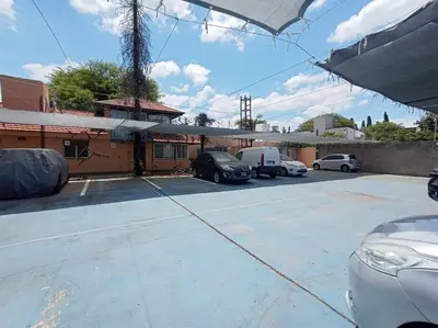 a parking lot with cars parked in front of a building at Cómodo Depto en B Villa Belgrano in Cordoba