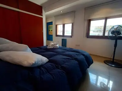 a bedroom with a blue bed with a fan at Cómodo Depto en B Villa Belgrano in Cordoba
