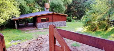 a small wooden cabin with a fence next to it at La vertiente in Villa Yacanto