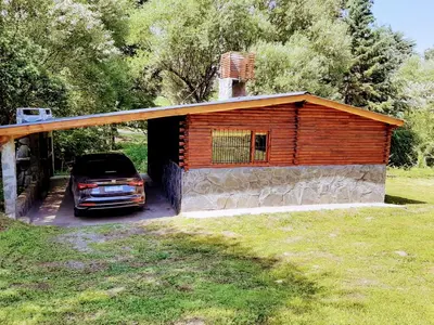 a building with a car parked in front of it at La vertiente in Villa Yacanto