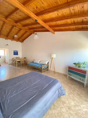 a large bedroom with a bed and a table at La Casita Yogui - MONOAMBIENTE 1 in Santa Rosa de Calamuchita