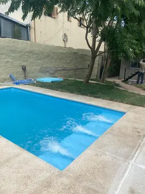 a blue swimming pool with a reflection of the sky at La Casita Yogui - MONOAMBIENTE 1 in Santa Rosa de Calamuchita