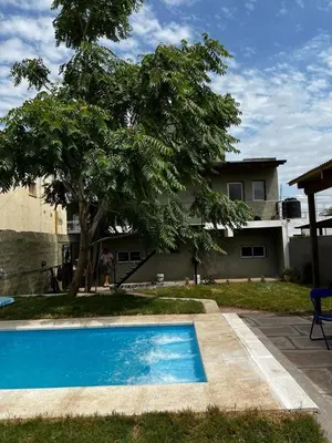 a blue swimming pool in front of a house at La Casita Yogui - MONOAMBIENTE 1 in Santa Rosa de Calamuchita