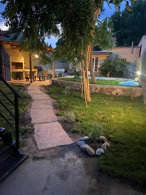 a walkway in a yard with a tree and a picnic table at La Casita Yogui - MONOAMBIENTE 1 in Santa Rosa de Calamuchita