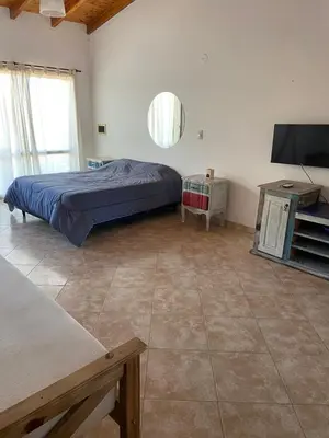 a bedroom with a bed and a flat screen tv at La Casita Yogui - MONOAMBIENTE 1 in Santa Rosa de Calamuchita