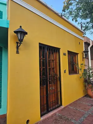 a yellow building with a door and a street light at Martinolli5130 in Cordoba