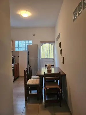 a kitchen with a table and chairs and a refrigerator at Martinolli5130 in Cordoba