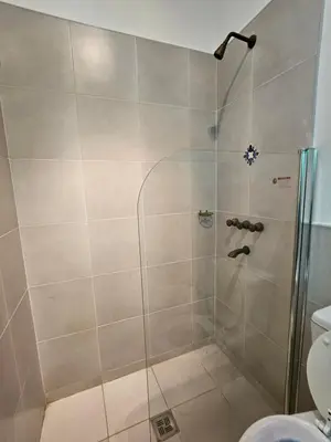 a shower with a glass door in a bathroom at Martinolli5130 in Cordoba
