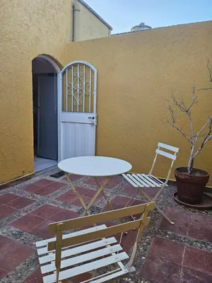 a table and two chairs sitting next to a building at Martinolli5130 in Cordoba