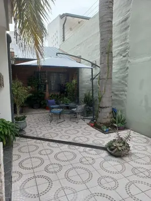 a patio with a table and a palm tree at Departamento interno con dos camas individuales in Cordoba