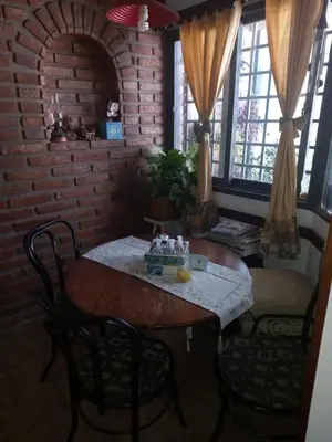 a table and chairs in a room with a brick wall at Departamento interno con dos camas individuales in Cordoba