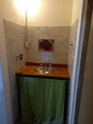 a bathroom with a sink and a green towel at Cabaña Serrana in Santa Rosa de Calamuchita