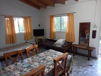 a living room with two beds and a tv at Cabaña Serrana in Santa Rosa de Calamuchita